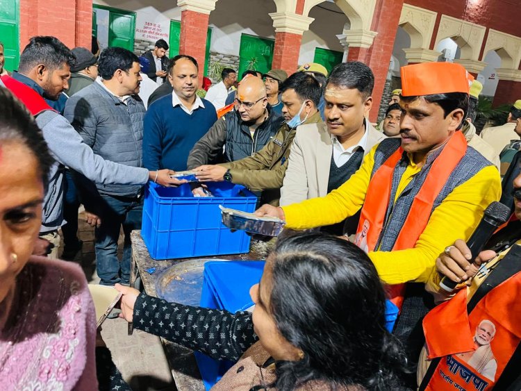 वाराणसी: जिलाधिकारी ने महाकुंभ से लौटे श्रद्धालुओं में खाद्य पैकेट वितरित किया